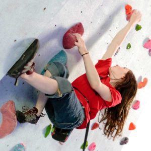 A woman bouldering at Summit Centre, South Wales