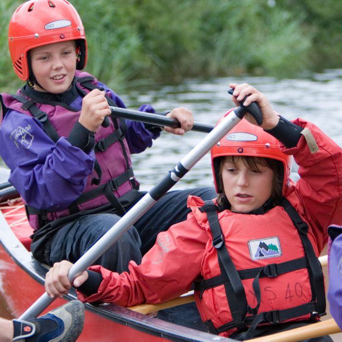 Seconday school children doing the watersports activity open canoeing at THE SWIFT CENTRE Adventure Centres