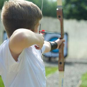 Boy doing archery at a THE SWIFT CENTRE centre 